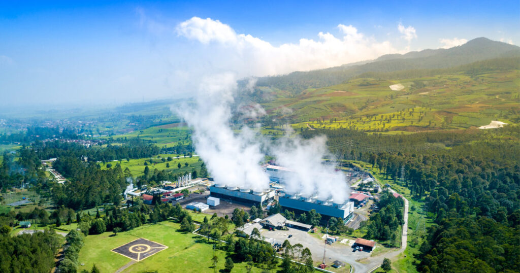 Aerial view of a geothermal energy plant with steam rising.