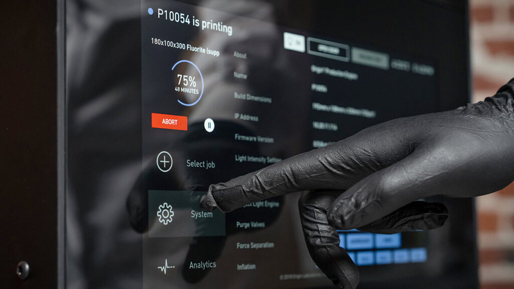 Hand in glove interacting with a 3D printer screen.