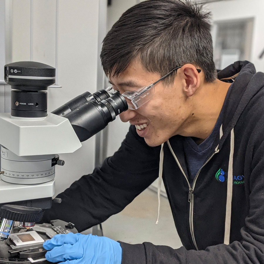 Man using a microscope in a lab setting.