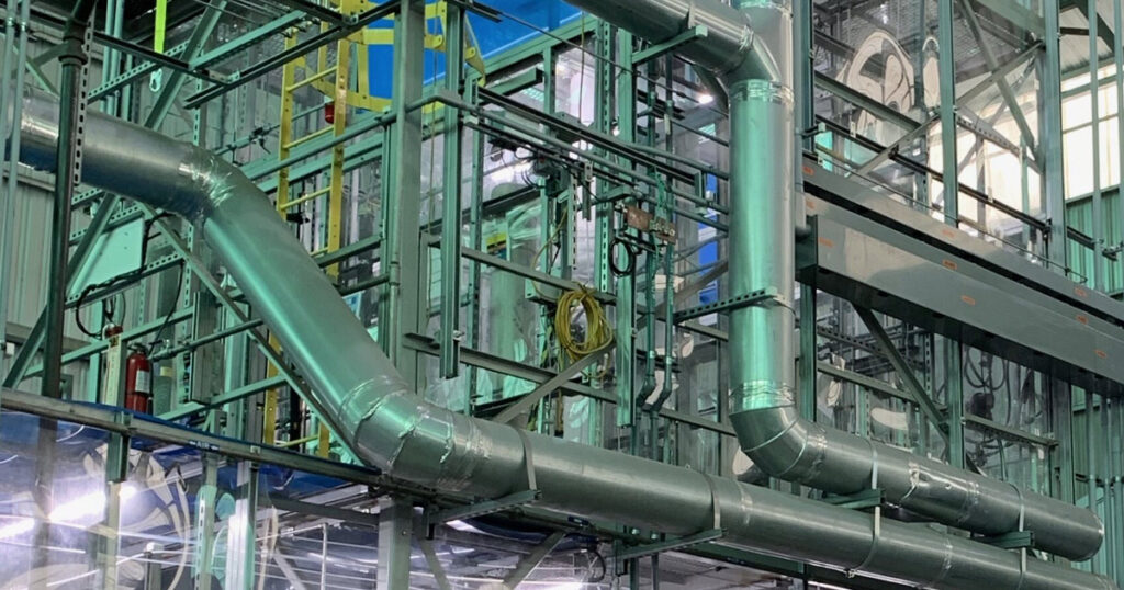 Complex network of industrial pipes and steel structures in a facility.