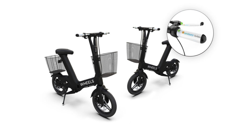 Two black Wheels electric scooters with front baskets showcasing handlebar details.