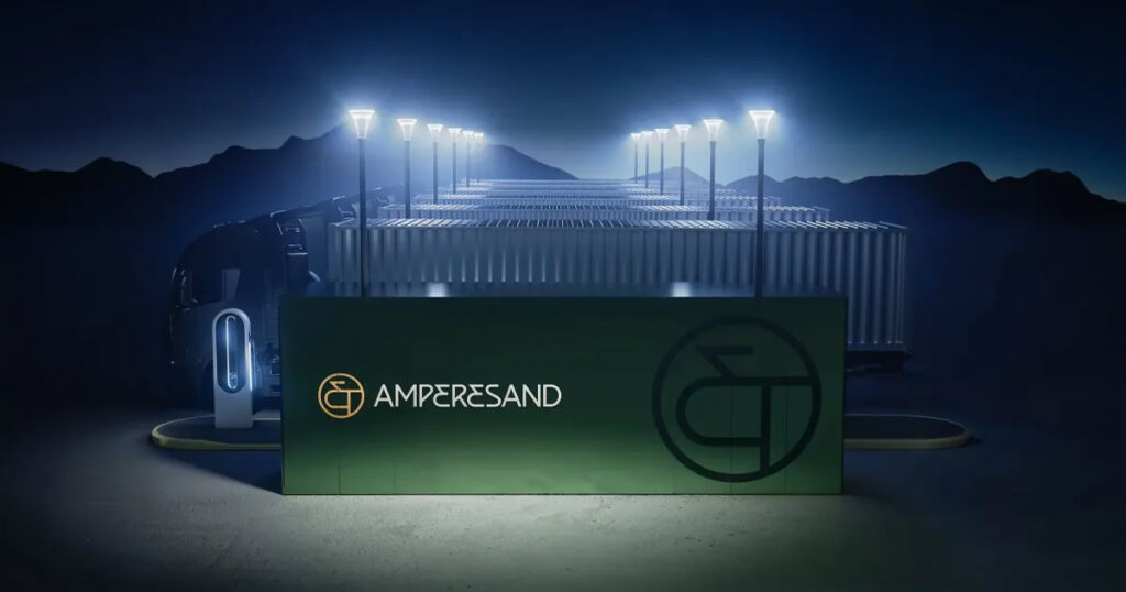 Ampersand's electric vehicle charging station illuminated at night with mountains in the background.