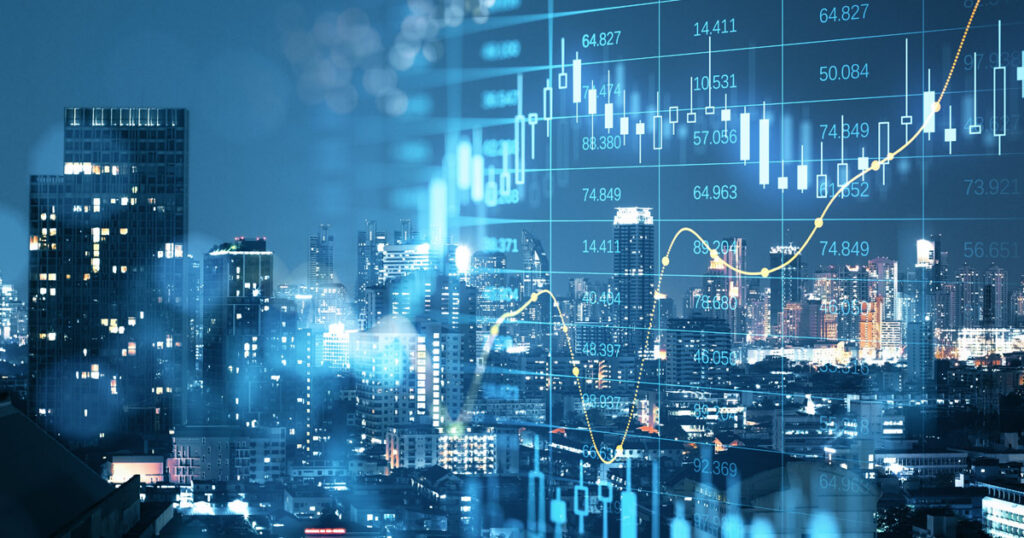 Stock market graphs superimposed on an illuminated cityscape at night.