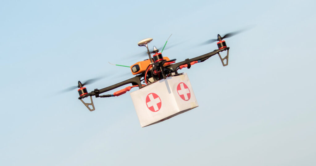 Drone carrying a first aid kit box in the sky for emergency delivery.