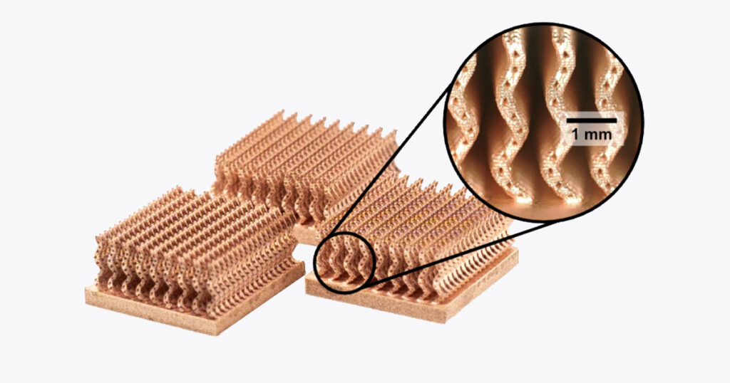 A US quarter dollar standing next to a small copper lattice structure on a platform.