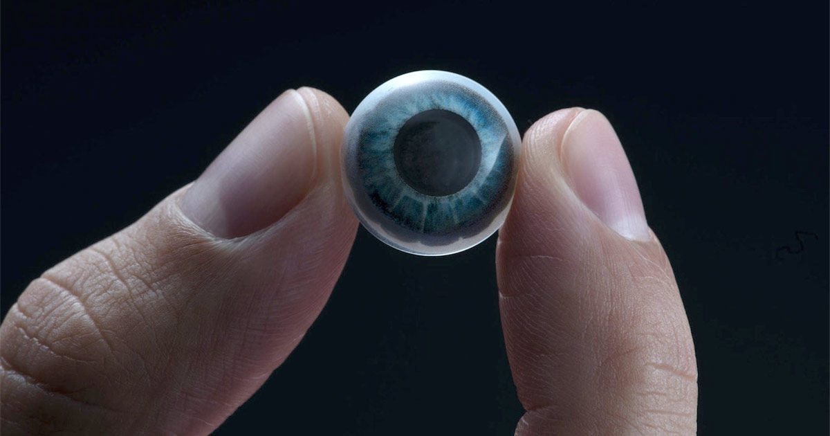 A Mojo Vision smart contact lens held between two fingers.