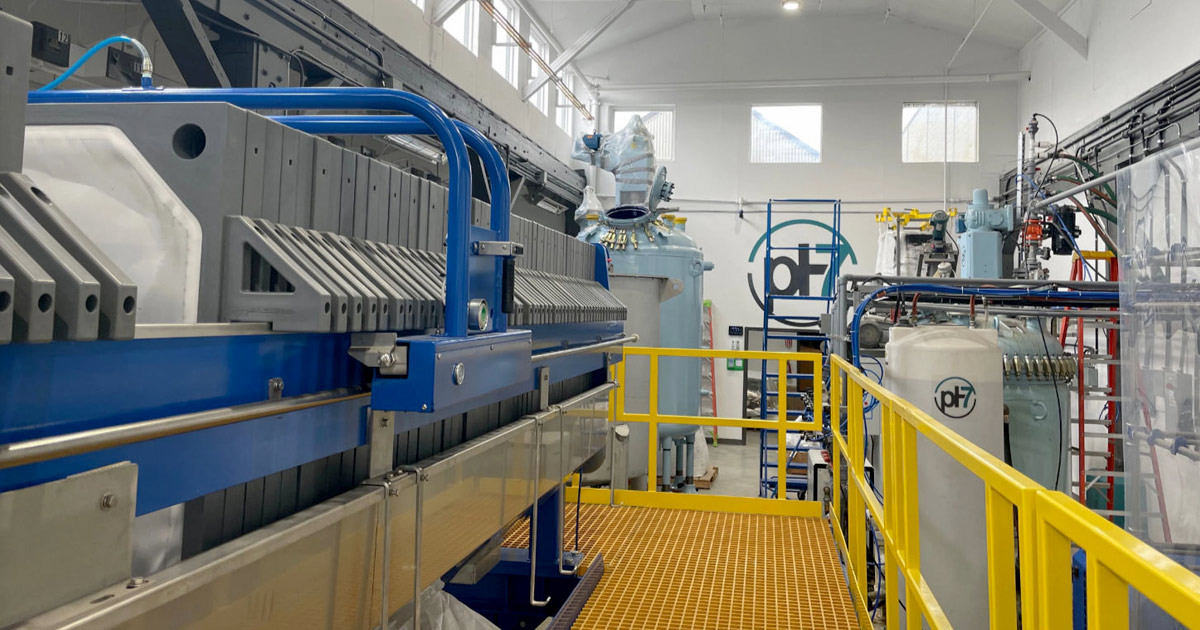 pH7 Technologies critical metals processing plant interior with machinery and safety railings.