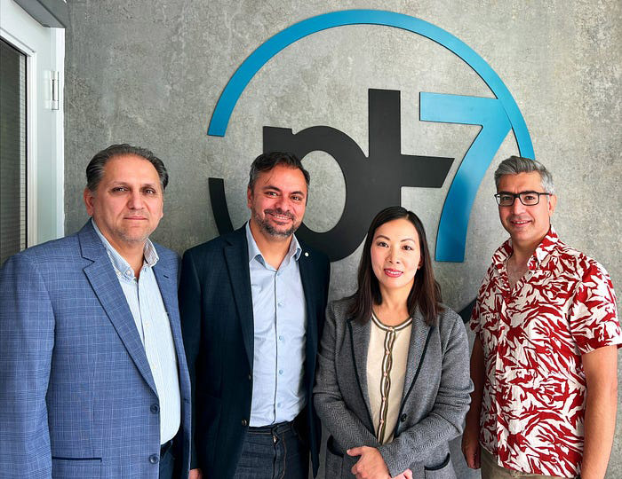 TDK Ventures and pH7 Technologies team members standing in front of the pH7 logo in an office setting.